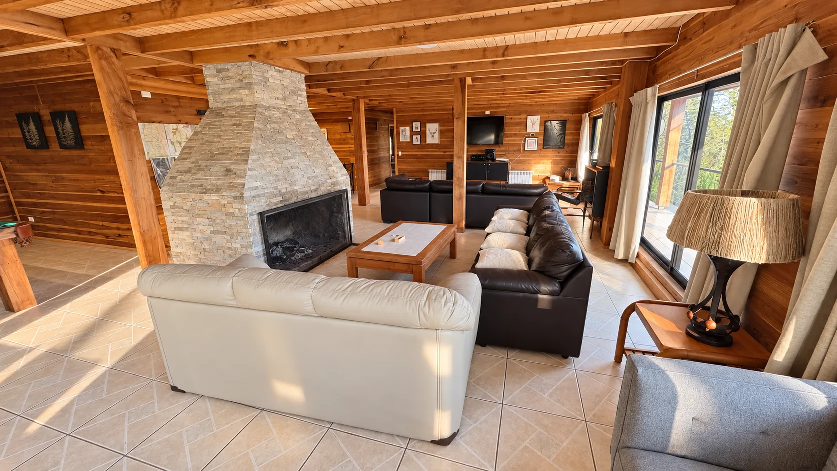 Living de madera con chimenea central y sofás